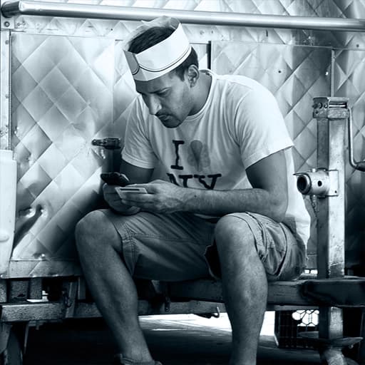 "A Chatloop language learner sitting by a cooler sending and reading text messages"